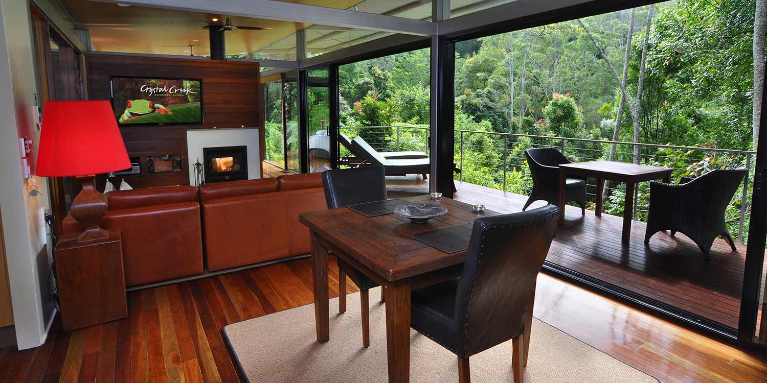 The glass walls and sliding doors of the Glass Terrace Bungalow bring the rainforest indoors. Click or tap to read more about this accommodation type.